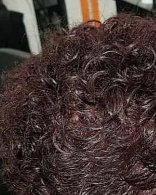 Après : coupe courte bouclée, coloration acajou profond, vue de dos