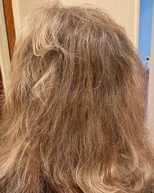 Avant : cheveux blond cendré mi-longs, crépus et non structurés, vus de dos
