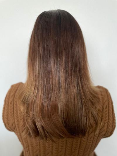 Balayage caramel cuivré sur cheveux longs lisses, racines châtain foncé